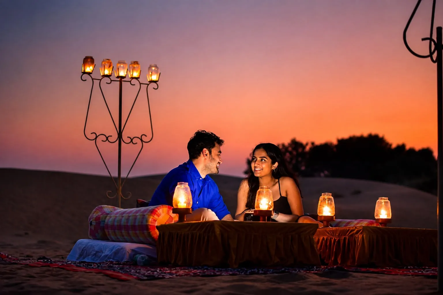 Couple enjoying a candlelight Dinner on the Dunes at sunset near Jaisalmer