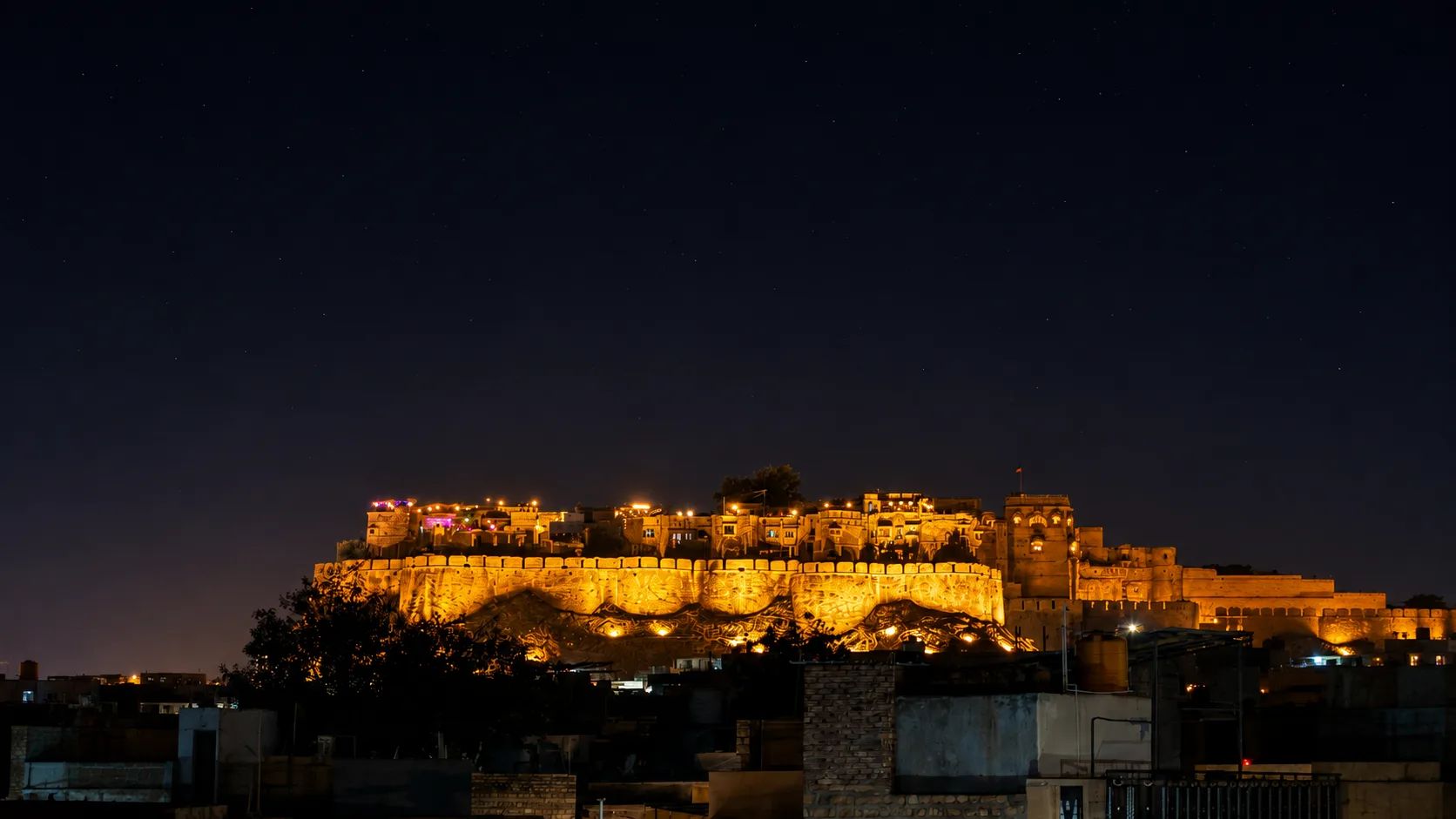 Jaisalmer Fort illuminated at night and camel and jeep safaris across the Thar Desert dunes at sunset
